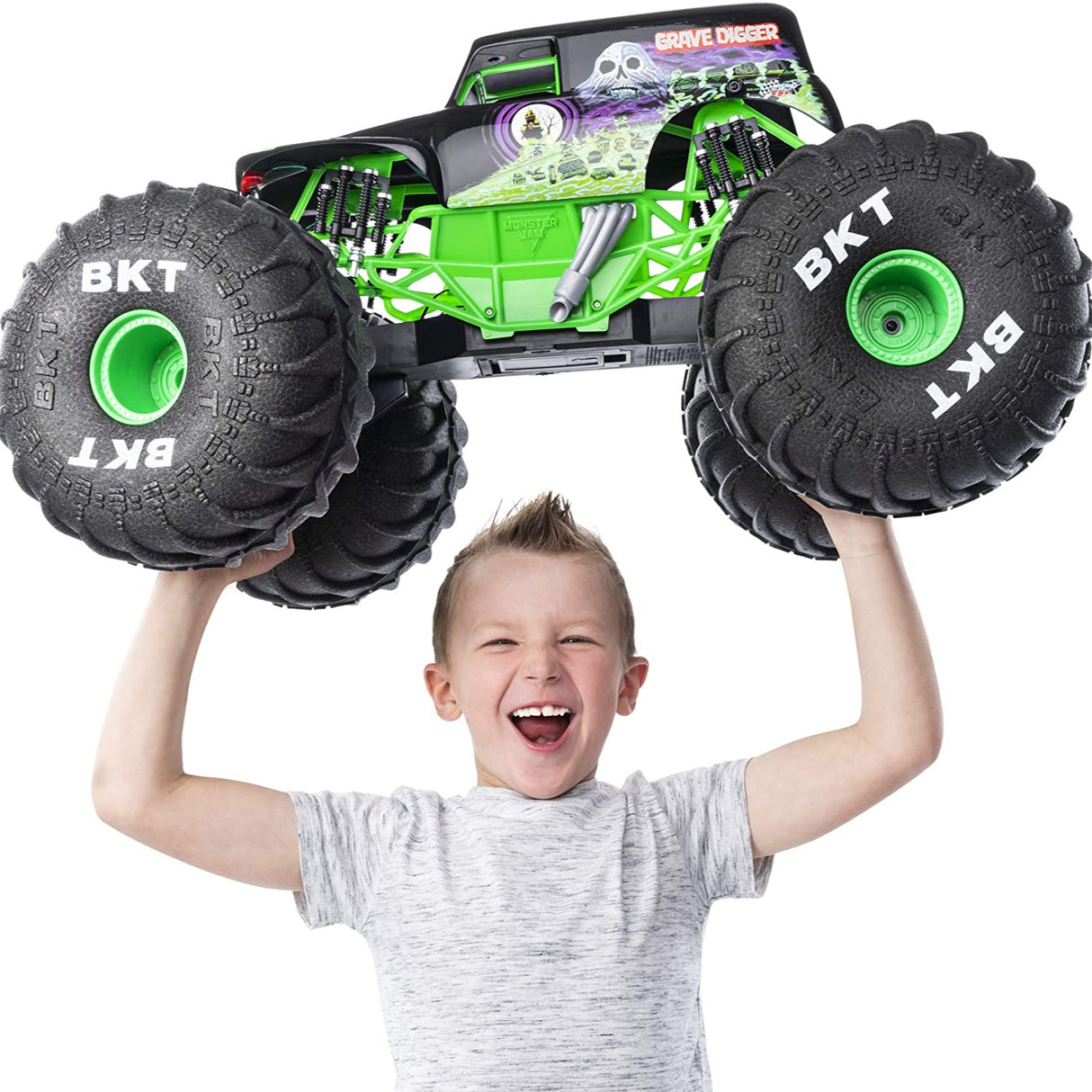 Young boy holding the HUGE RC Grave Digger monster truck with large BKT tires and authentic graphics above his head.