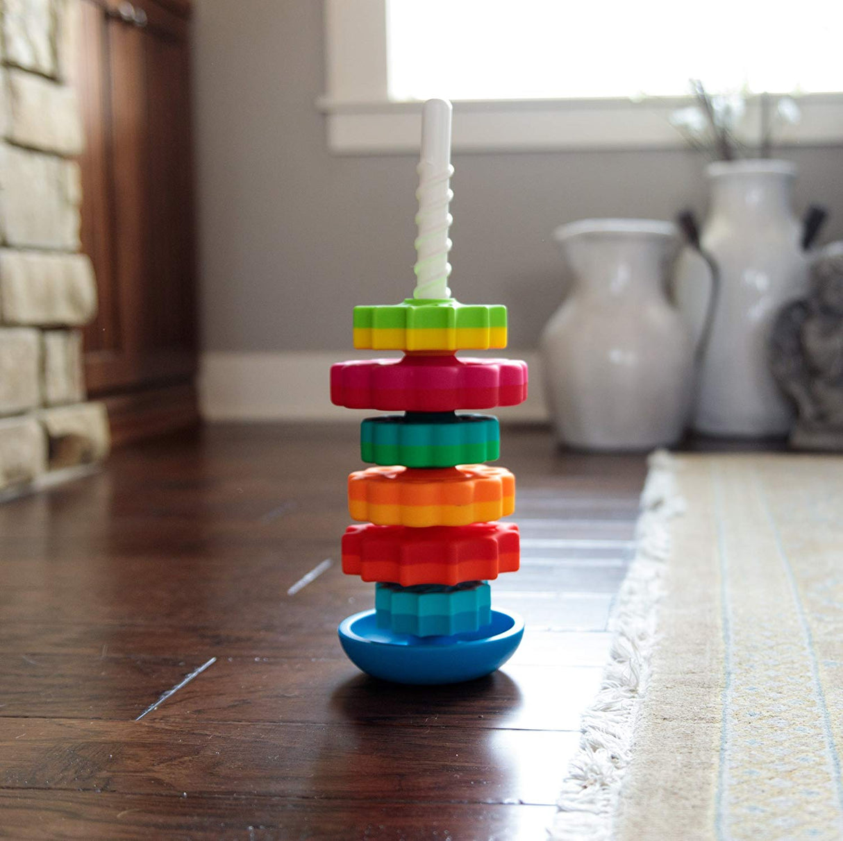 SpinAgain stacking toy with colorful star-like discs on reversible wobble base and corkscrew pole for toddlers.