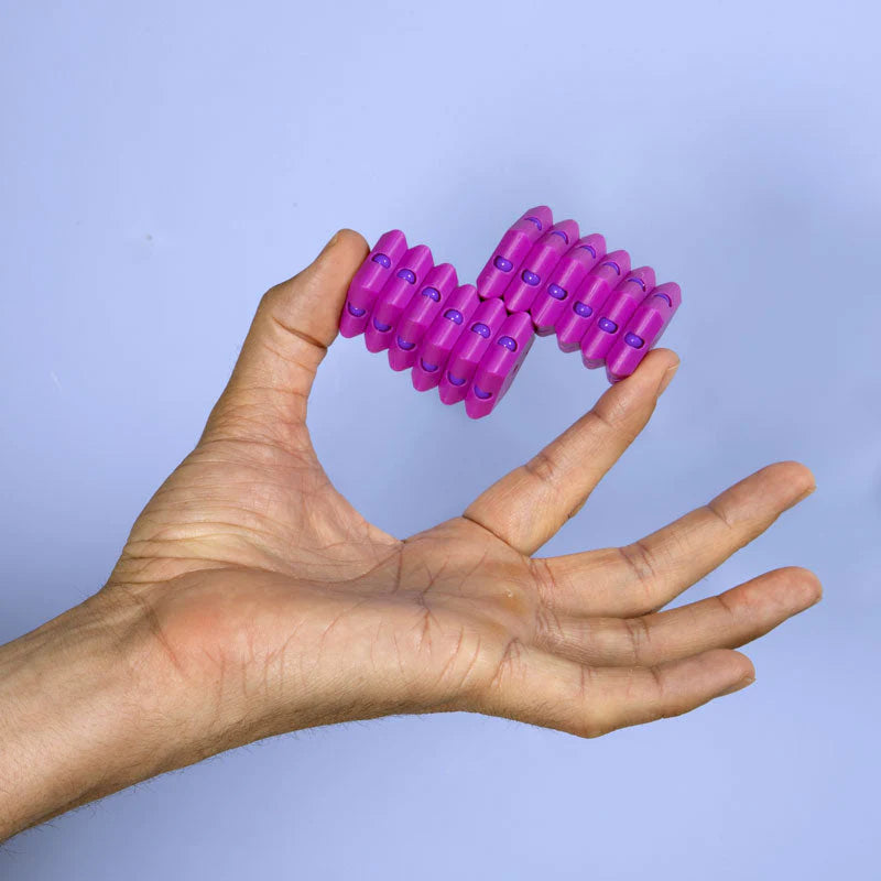 Hand holding a purple Geode Razzle fidget desk toy made of 12 snapping pentagons for focus and sensory play