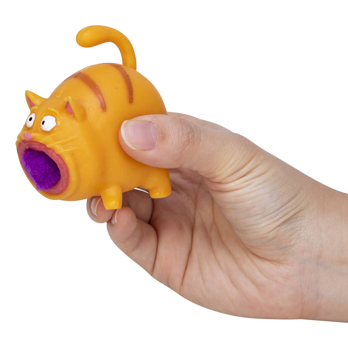 Hand squeezing the orange Hairball Kitty toy with a purple pom pom hairball inside its mouth.