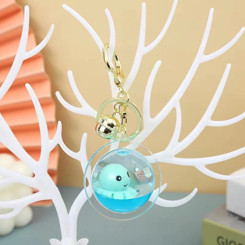 Octopus Floaty Keychain featuring a small blue octopus inside a clear floaty orb with gold clip and keyring attachment.