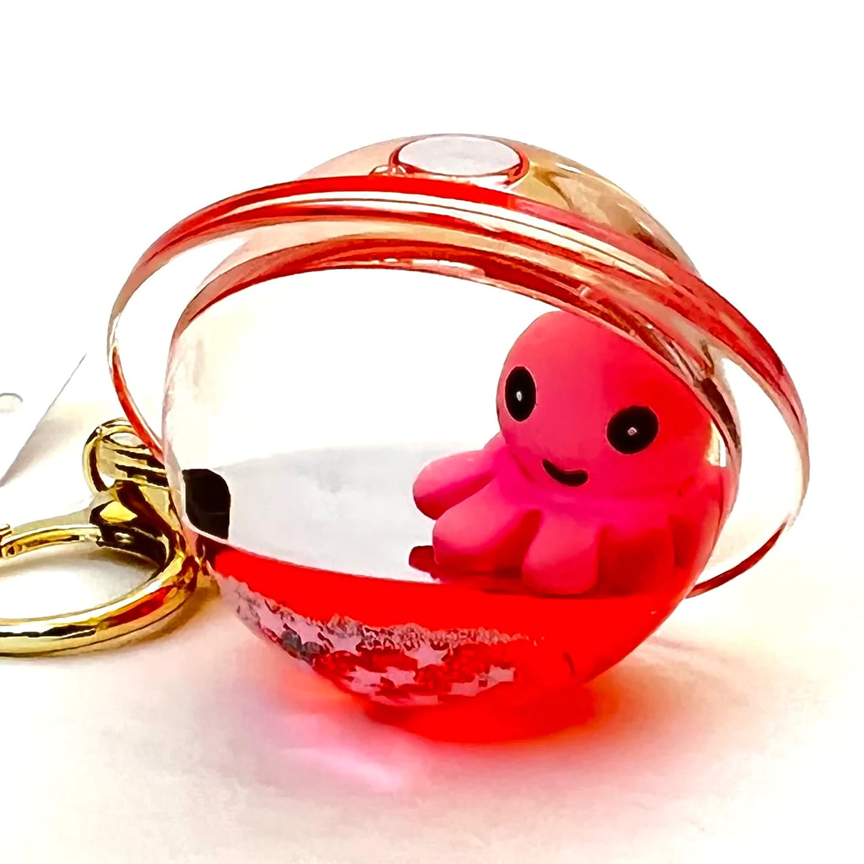 Octopus Floaty Keychain featuring a cute pink octopus inside a clear red floaty ball with clip and keyring attachment.