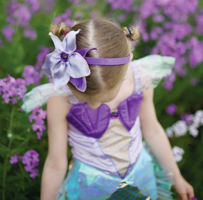 Little girl in Mermaid Dress & Headband Lilac | Size 5-6 with purple shells and holographic sea blue skirt in garden.