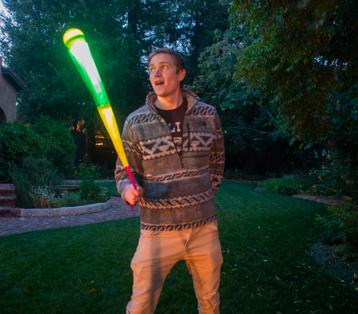 Man playing outdoors at night with glowing Foxtail LED Softie foam ball with colorful light and nylon tail