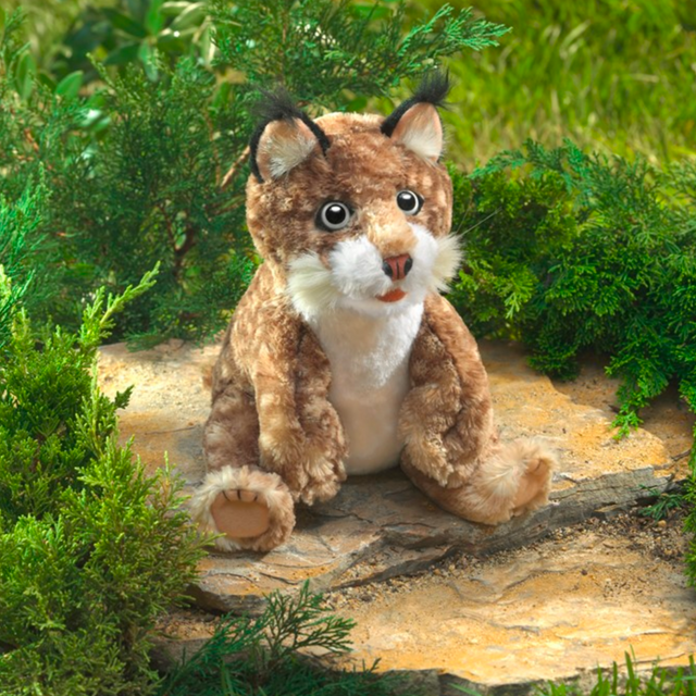 Folkmanis Bobcat Kitten plush puppet sitting outdoors with soft spotted fur and movable features for kids 3+.