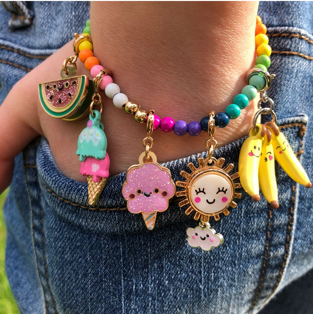 Gold Rainbow Stretch Bead Bracelet with colorful beads and cute charms including ice cream, sun, and bananas on a child’s wrist.