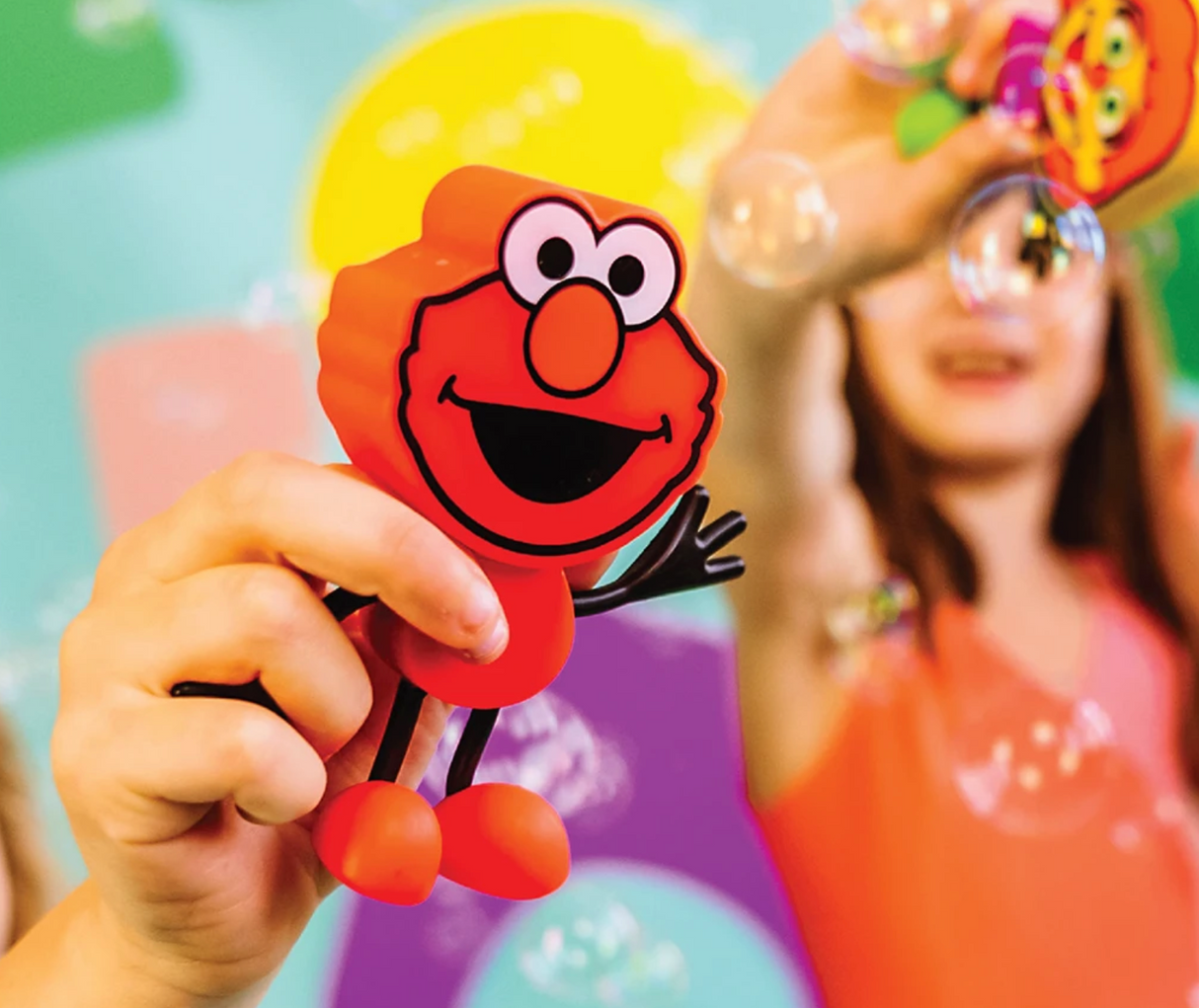 Glo Pals Elmo Character held by child with bubbles in colorful background, playful and friendly toy for kids.