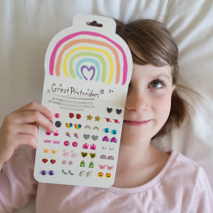 Child holding colorful Great Pretenders Stick On Earrings | Rainbow Love pack with hearts, rainbows, and butterflies for ages 3+.