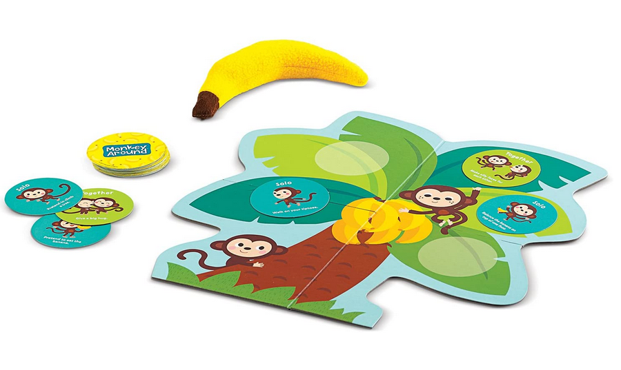 Monkey Around game with colorful monkey cards, a banana bean bag, and a playful tree-shaped game board for kids.
