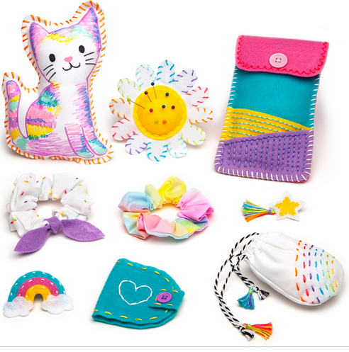 Bright handmade fabric crafts including a cat, flower, and pouches from the Let's Learn to Sew kit for kids.