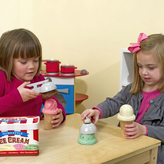 Two children playing with the Scoop & Stack Ice Cream Set, using magnetic scoopers and wooden cones.