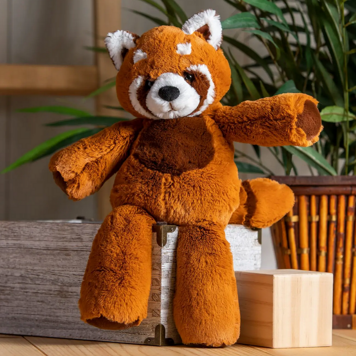 Marshmallow Red Panda plush toy sitting on wooden blocks with soft fabric and embroidered details.