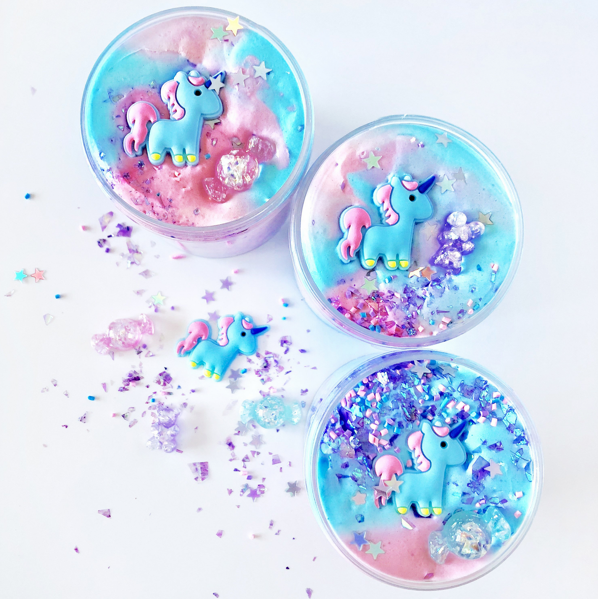 Don't Feed the Unicorns Butter Slime with pastel colors, unicorn charms, glitter, and star sprinkles in clear containers.