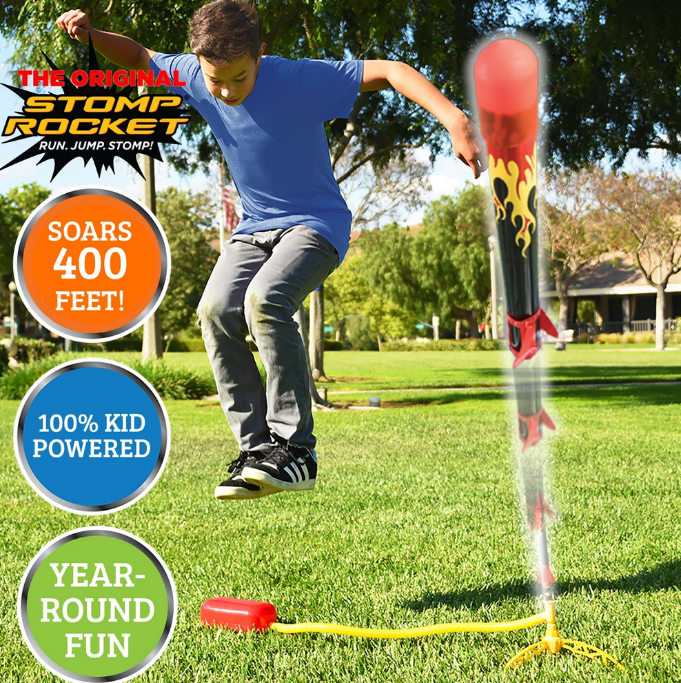 Boy stomping to launch the Stomp Rocket X-Treme! rocket outdoors, soaring high in sunny park grass.