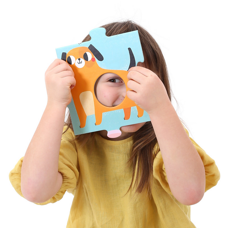 Child holding a dog puzzle piece from the 50pc Suuper Alphabet Match Floor Puzzle learning set.