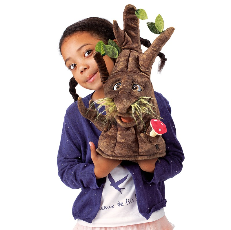 Child holding the Enchanted Tree Puppet with moveable eyes, limbs, and a red mushroom detail.