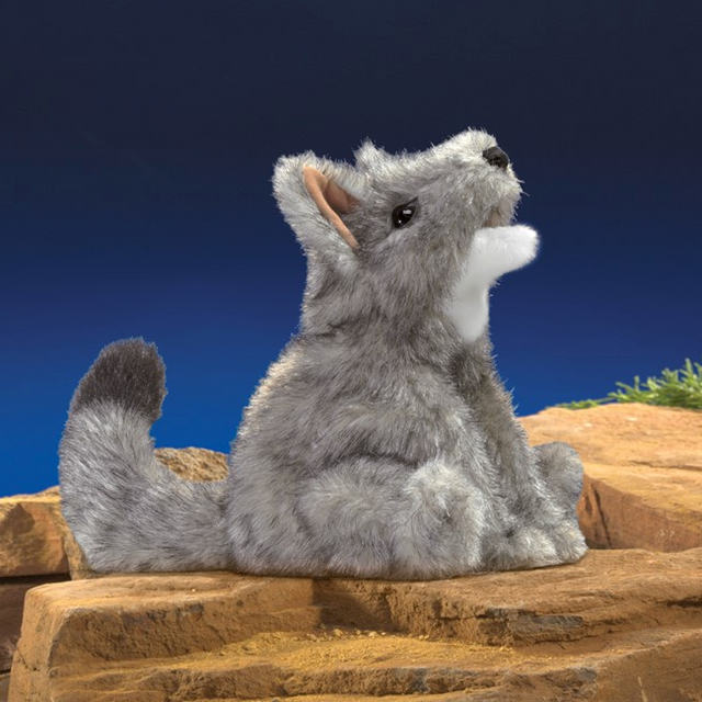 Coyote Puppet with movable mouth and fore legs in iconic pose, 9 inches long, soft gray fur on rocky surface.