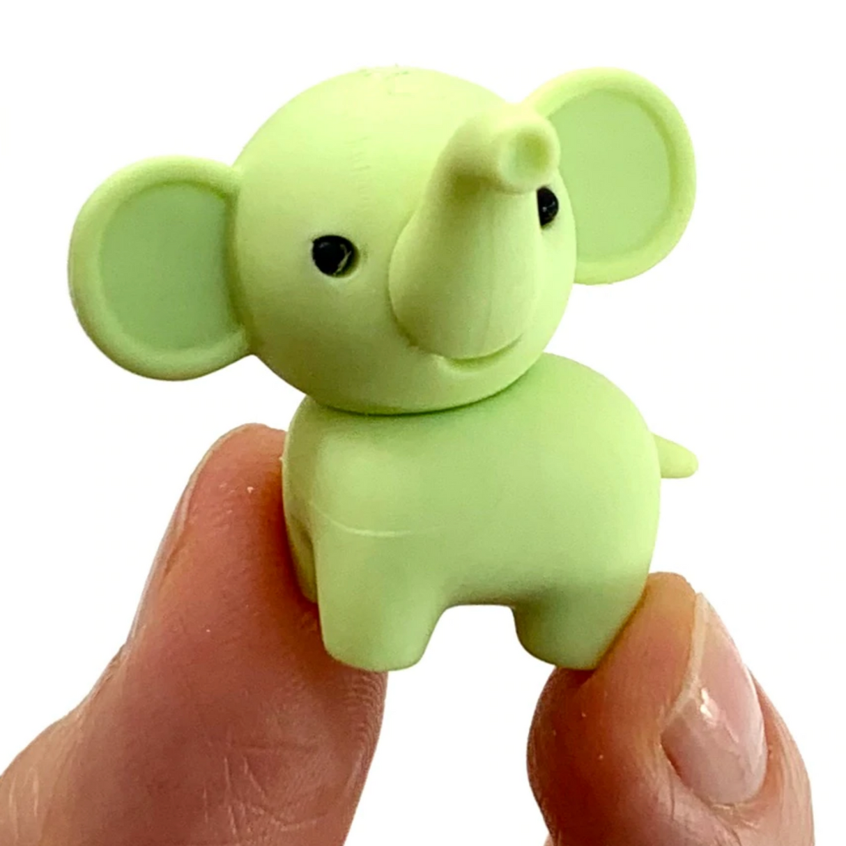 Japanese Eraser Elephant held between fingers, small eco-friendly handmade puzzle eraser toy in light green color.