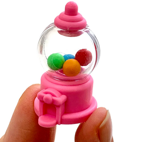 Hand holding pink Japanese Eraser Candy shaped like a gumball machine with colorful balls inside.