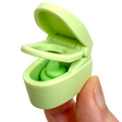 Japanese Eraser Toilet in green held between fingers, showing the open lid and puzzle eraser inside.