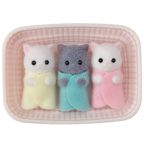 Persian Cat Triplets showing three tiny fluffy kittens wrapped in pastel blankets lying in a pink cradle.