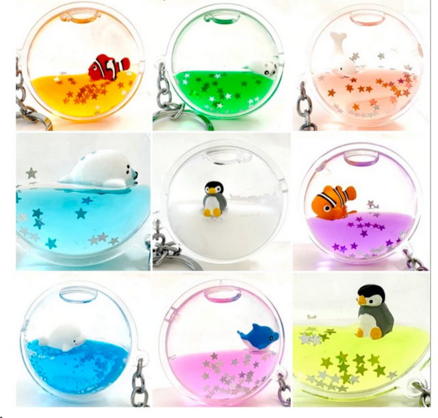 Floating Sea Charm KeyChain with assorted colorful sea creatures and glitter inside a round clear casing.