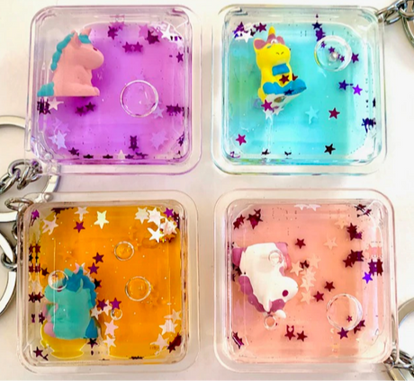 Floating Unicorn KeyChain with colorful liquid and glitter, featuring assorted unicorns in a clear square casing.