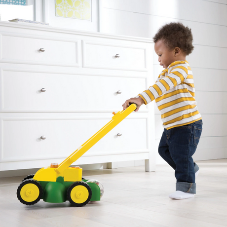 Child playing indoors with John Deere Lawn Mower toy, an interactive lawn mower for toddlers and preschool kids.