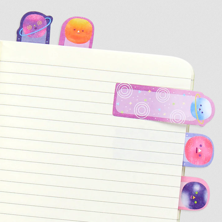 Note Pals Planet sticky tabs with cute space and planet designs in soft pink, purple, and yellow shades on notebook pages.
