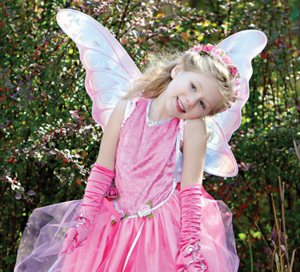 Gold Pastel Wings worn by a smiling girl in a pink fairy costume outdoors, with satin-lined elastic and glitter accents.