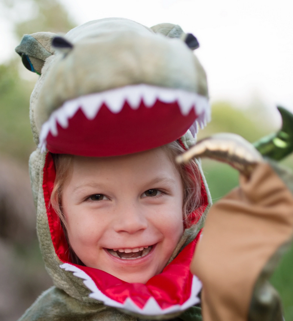 Grandasaurus T Rex Cape with Claws worn by smiling child with dinosaur head and removable mouthpiece outdoors.