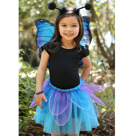 Young girl wearing the Midnight Butterfly Set with blue glitter wings, petal skirt, and butterfly antennae headband outdoors.