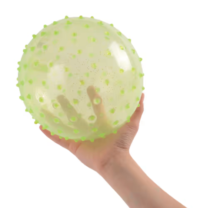 Hand holding a 5-inch Knobby Ball | Glitter Translucent with green knobs, designed for kids' easy grip and play.