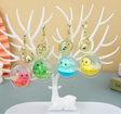 Octopus Floaty Keychain in assorted colors with clip and keyring, floating inside clear orb, displayed on white tree stand.