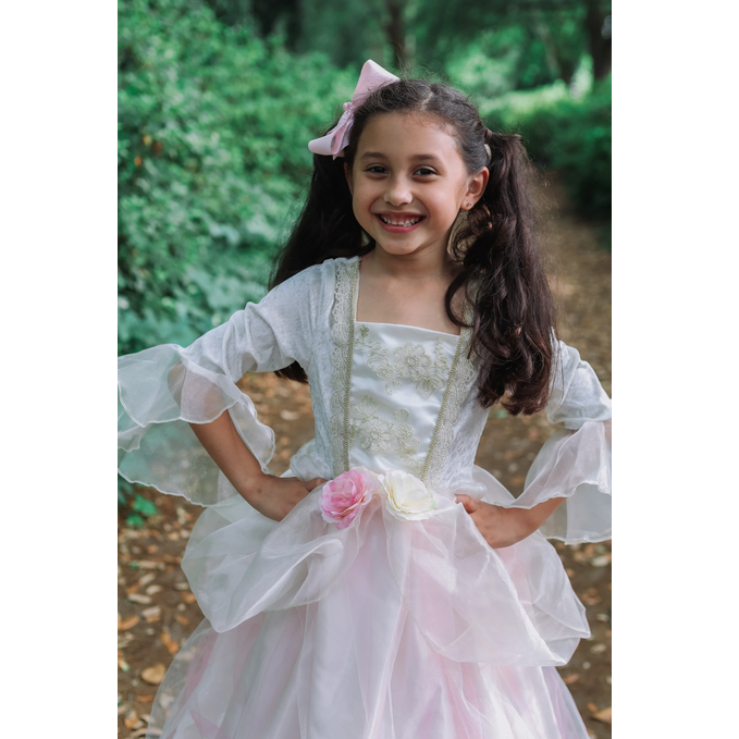 Smiling girl wearing Golden Rose Princess Dress with floral waistband and layered silky skirt outdoors.
