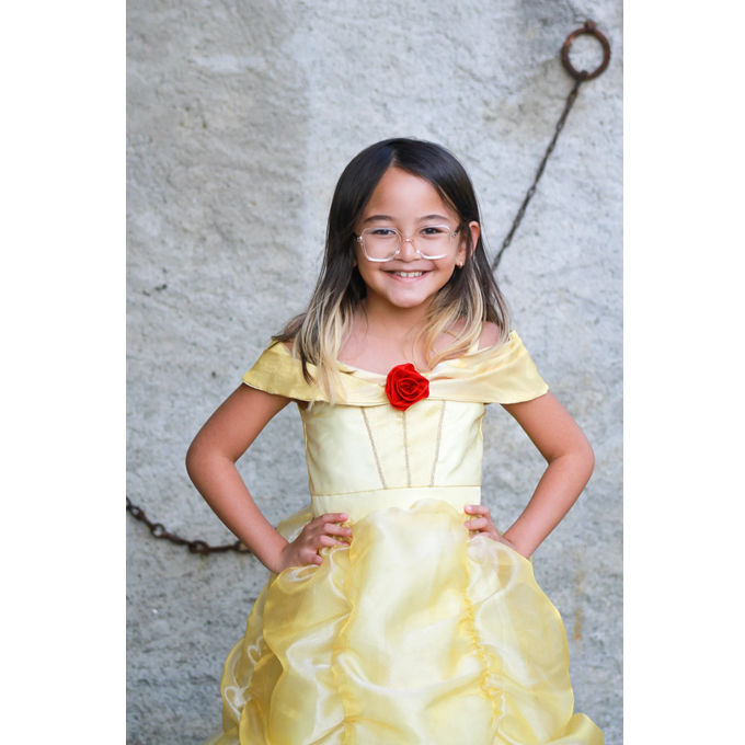 Girl wearing the Belle Boutique Gown Size 5-6 in pale yellow with off-shoulder design and red rose detail at chest.