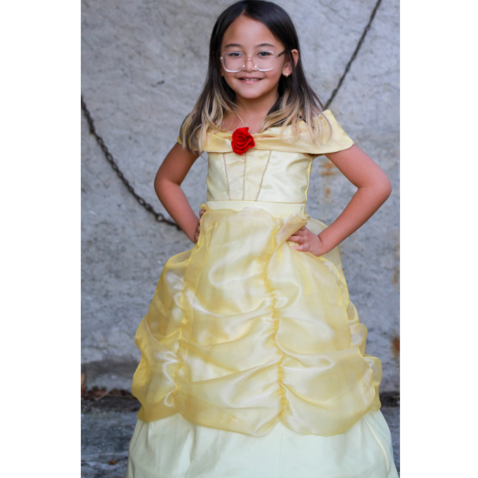 Girl wearing Belle Boutique Gown | Size 5-6 in pale yellow with off-the-shoulder style and red rose detail.