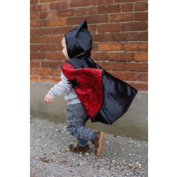 Toddler wearing Baby Spider Bat Reversible Cape Size 2-3 with black bat hood and red spider web cape.
