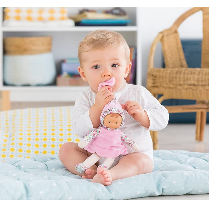 Baby holding and mouthing Miss Blossom Garden soft doll dressed in pink with vanilla scent, perfect for newborns.