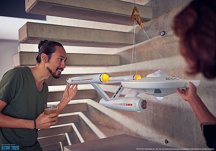 Two people examining a detailed Star Trek | Enterprise NCC1701 model in a modern setting.