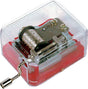 Mechanical Music Box with visible crank and gears inside a clear red casing, pocket-sized classical music player.