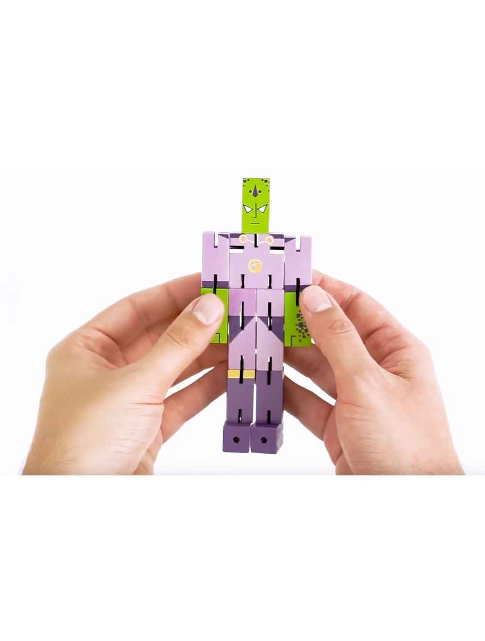 Hands holding a purple and green wooden figure of Puzzle Planet Emperor brainteaser puzzle toy.