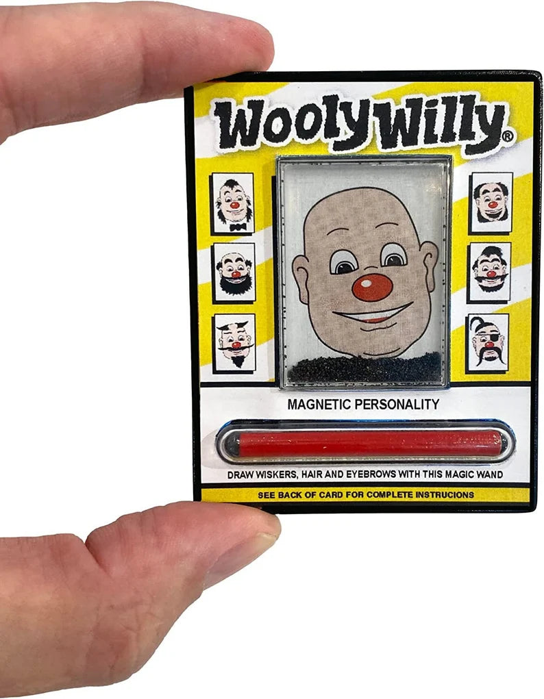 Hand holding the World's Smallest Wooly Willy magnetic drawing toy with face and red magnetic wand.