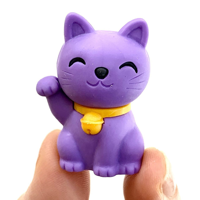 Japanese Eraser Maneki Cat in purple with a yellow bell collar, smiling and waving, eco-friendly and handmade puzzle eraser.