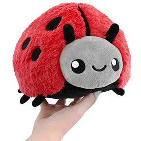 Ladybug Mini plush toy in red with black spots, soft and squishy, held in hand, perfect for kids ages 3 and up.