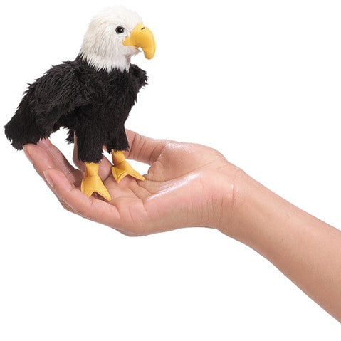 Eagle Finger Puppet shown on a hand, featuring black and white feathers and a yellow beak, perfect for imaginative play.