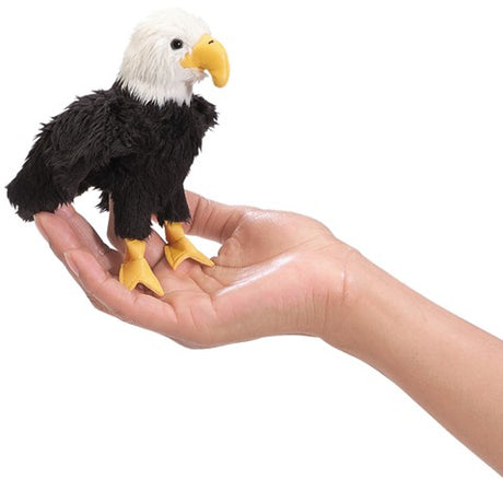 Eagle Finger Puppet shown on a hand, featuring black and white feathers and a yellow beak, perfect for imaginative play.