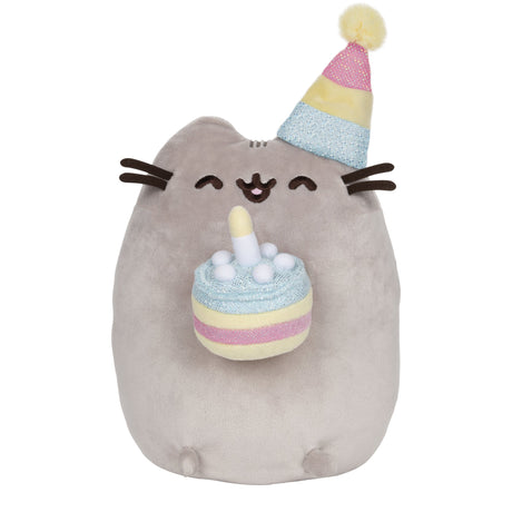 Pusheen Birthday Cake plush with smiling cat in pastel party hat holding a shimmering birthday cake with candle.