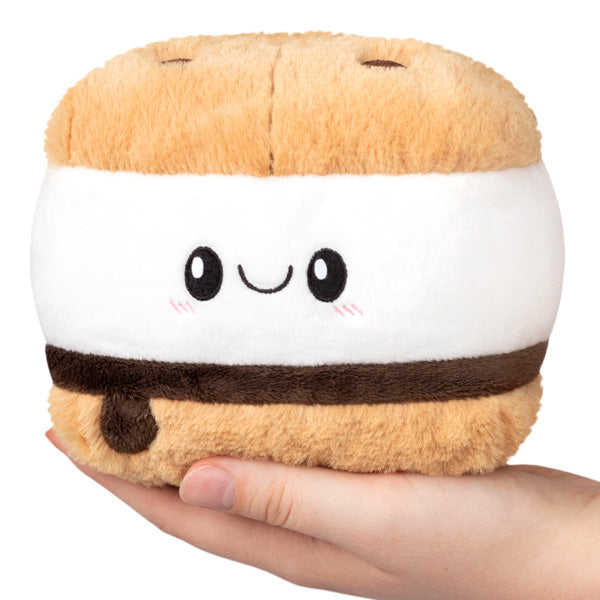 Hand holding a smiling, plush S'More Snackers toy made of soft polyester fiber, perfect for all ages.