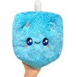 Hand holding a blue furry plush Dreidel Mini with a smiling face and embroidered Hebrew letters.